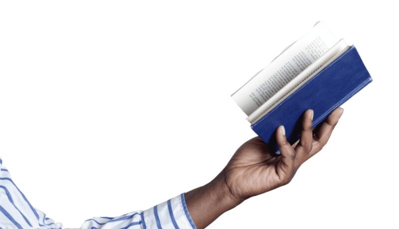 Hand holding an open book with a blue cover against a white background.